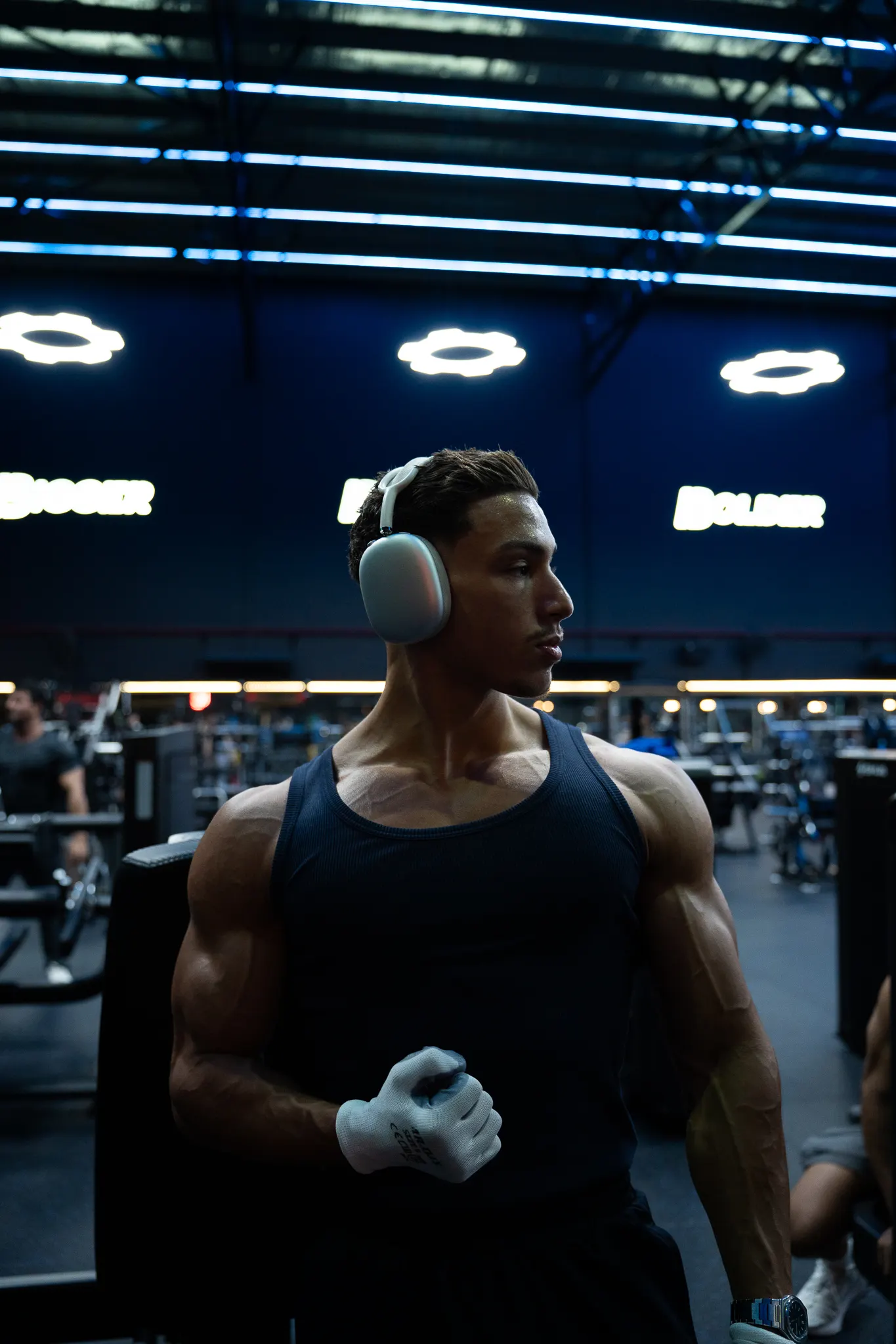 Rayan in een blauw verlichte sportschool, gefocust op zijn training